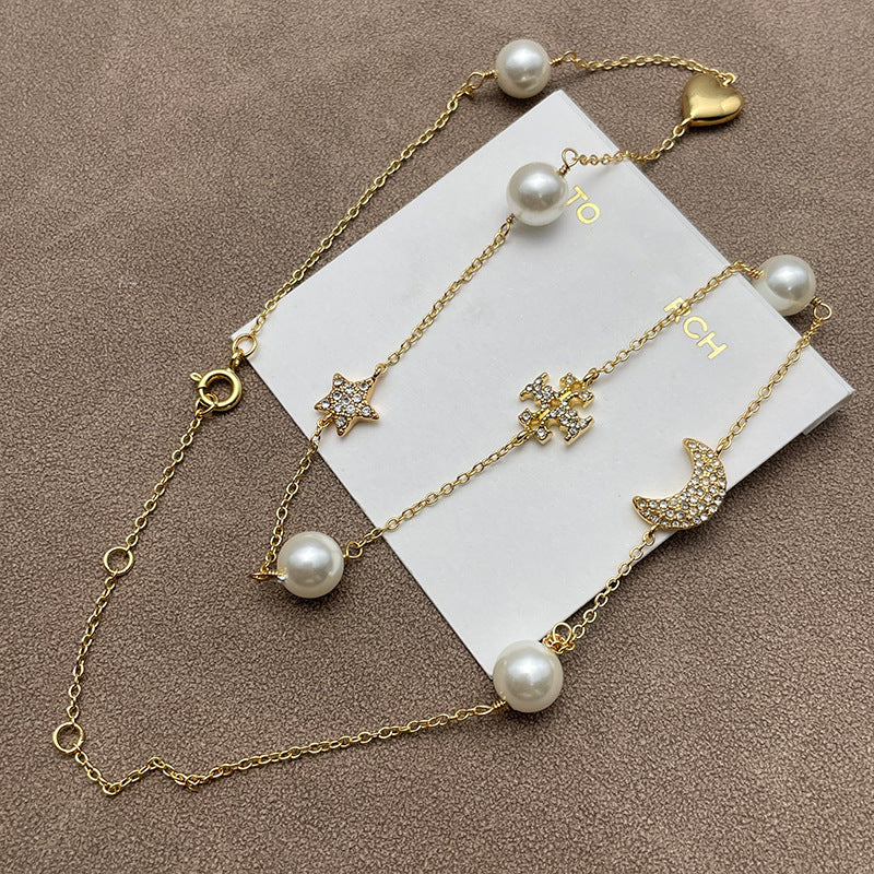 Close-up focusing on the star and moon charms, highlighting the pave crystal setting and the intricate metalwork.