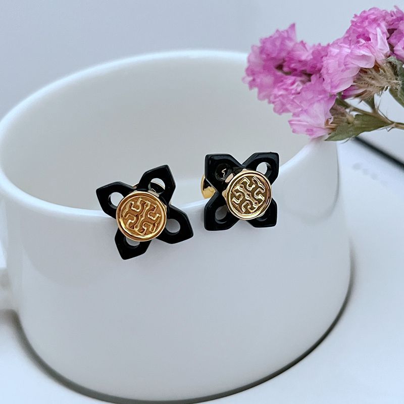 A curated flat-lay showing multiple pieces (e.g., earrings and a necklace) against a clean, light background, highlighting the beautiful tortoise shell pattern and gold logo details.