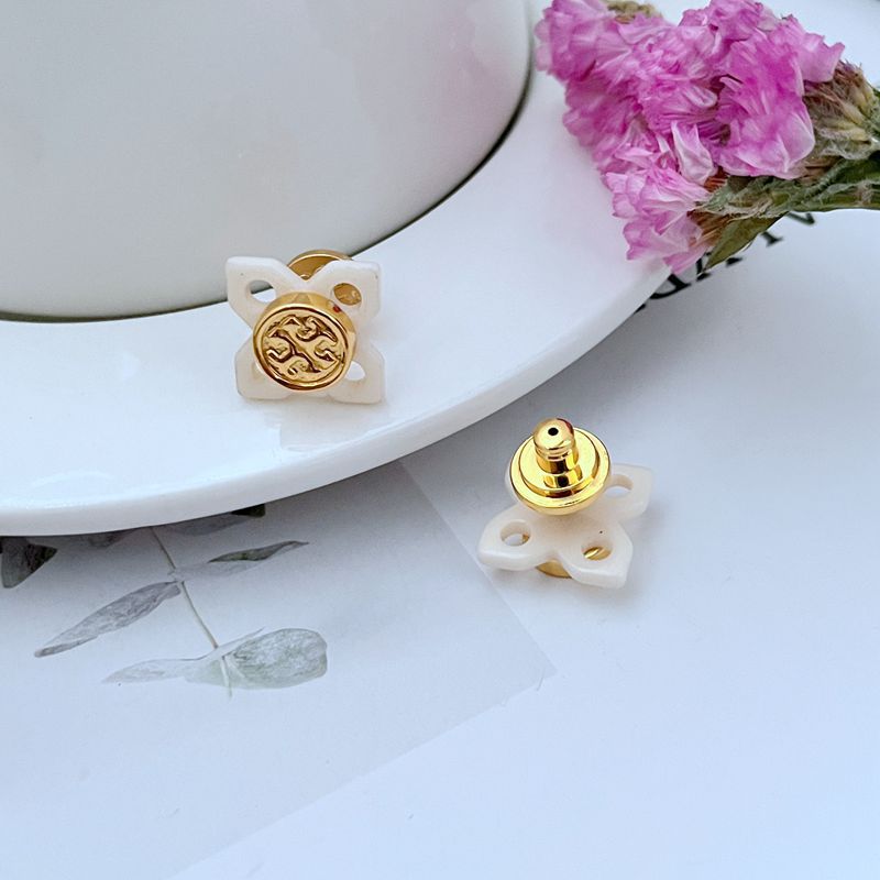  Macro shot focused on the intricate, glossy tortoise shell patterning and the adjacent polished gold logo, showcasing the textural contrast.