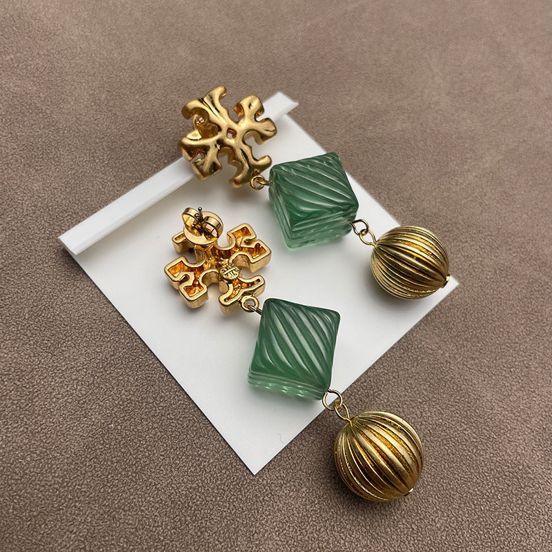 Close-up focusing on where the tortoiseshell pattern meets the gold floral or logo element, showcasing craftsmanship and material interplay.