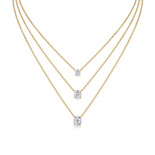 Clean white background — three oval moissanite pendants in graduated sizes, each on its own chain, layered elegantly on a bust form. The ovals catch light from multiple angles, showcasing the brilliant cut's signature sparkle.
