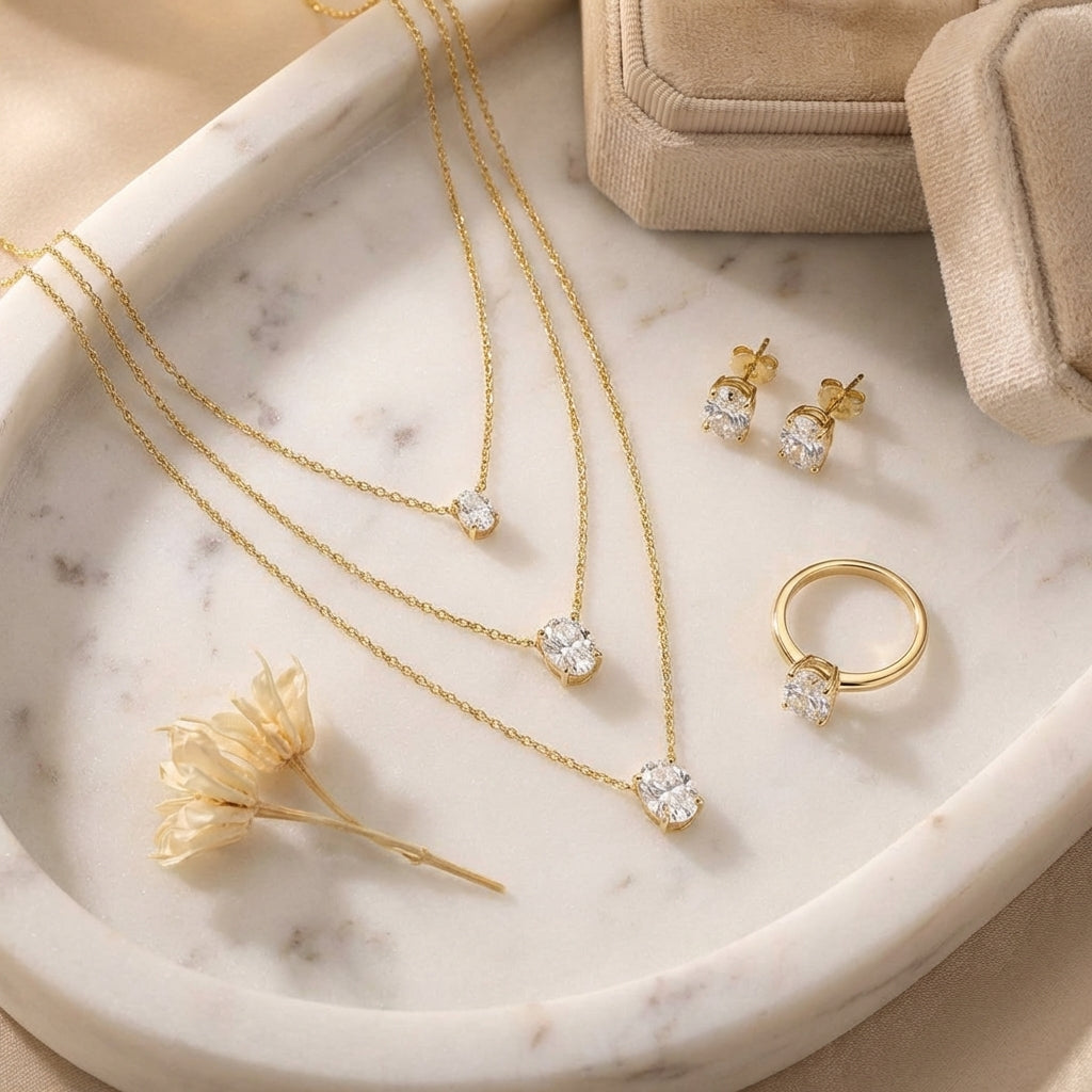 Top-down, necklaces on marble tray, styled with earrings, ring, dried flower, velvet box, warm soft tones, balanced composition, clean e-commerce aesthetic, high resolution.