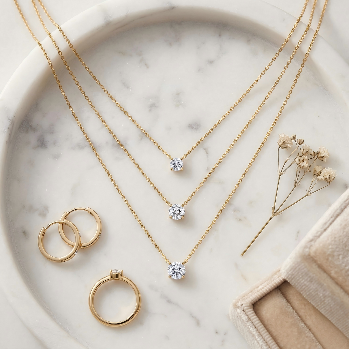 Top-down flat lay of the necklace on a white marble tray, styled with earrings, ring, dried flowers and a velvet jewelry box, soft warm tones, balanced composition, elegant e-commerce aesthetic.