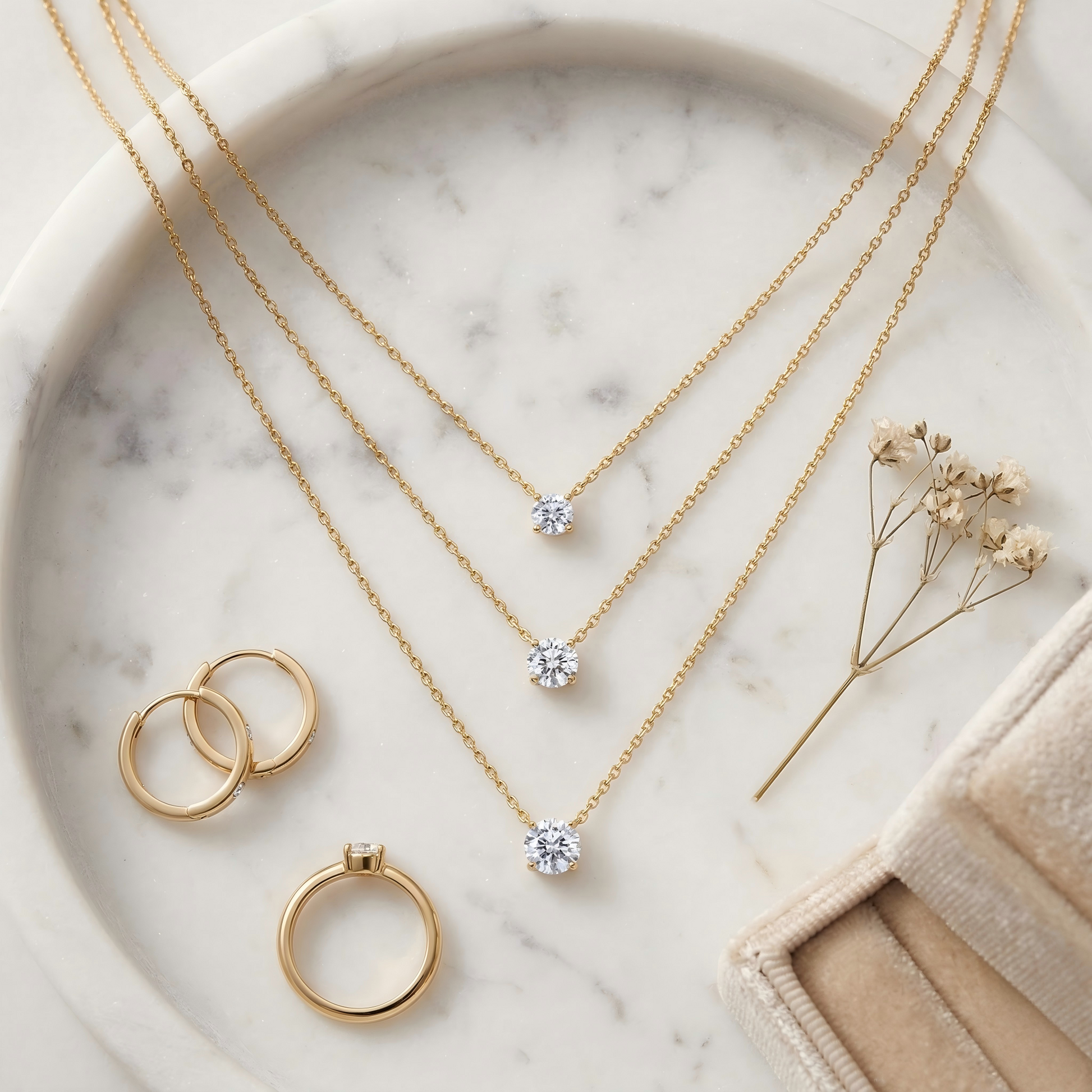 Top-down flat lay of the necklace on a white marble tray, styled with earrings, ring, dried flowers and a velvet jewelry box, soft warm tones, balanced composition, elegant e-commerce aesthetic.