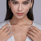 Model wearing the necklace layered with other necklaces in a stack.