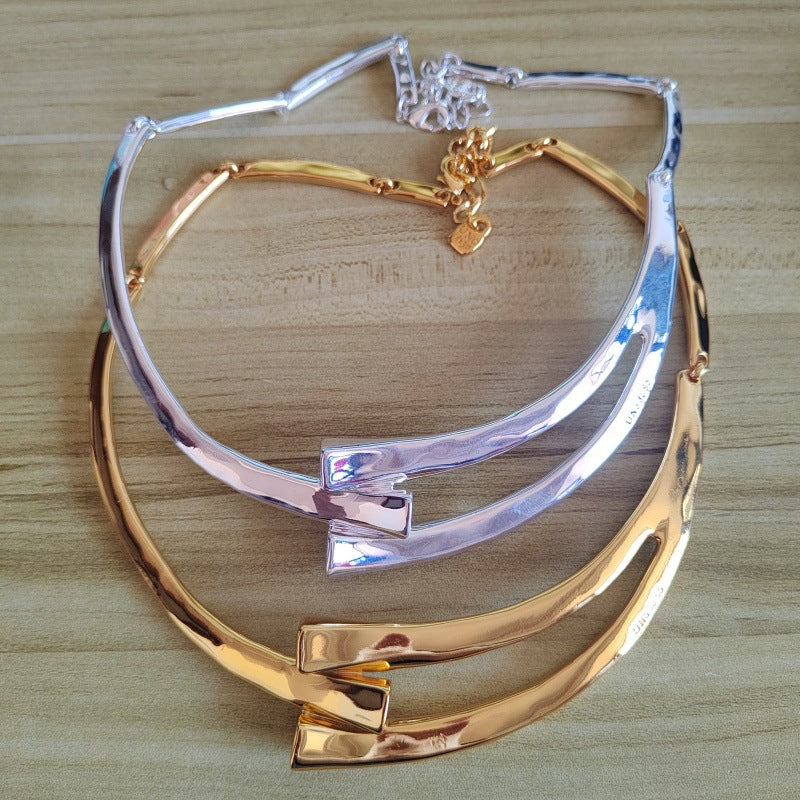 Choker on neutral background showing sculptural form. Alt: “UNO de 50 Sculpted Choker Necklace – Textured Silver Collar.”