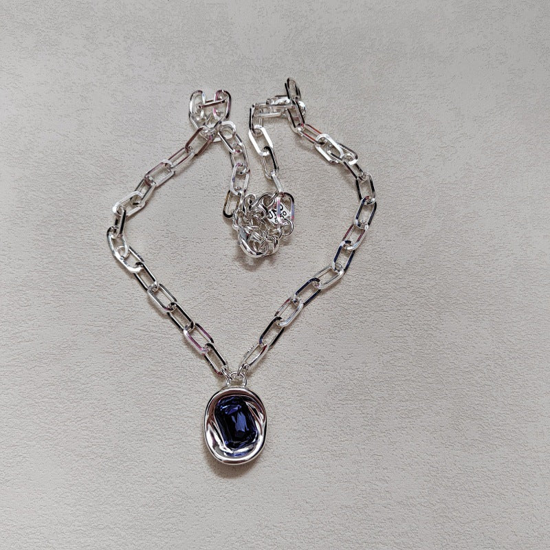  Necklace on neutral or jewel-tone background. Alt: “UNO de 50 Short Link Chain Pendant Necklace with Purple Crystal.”