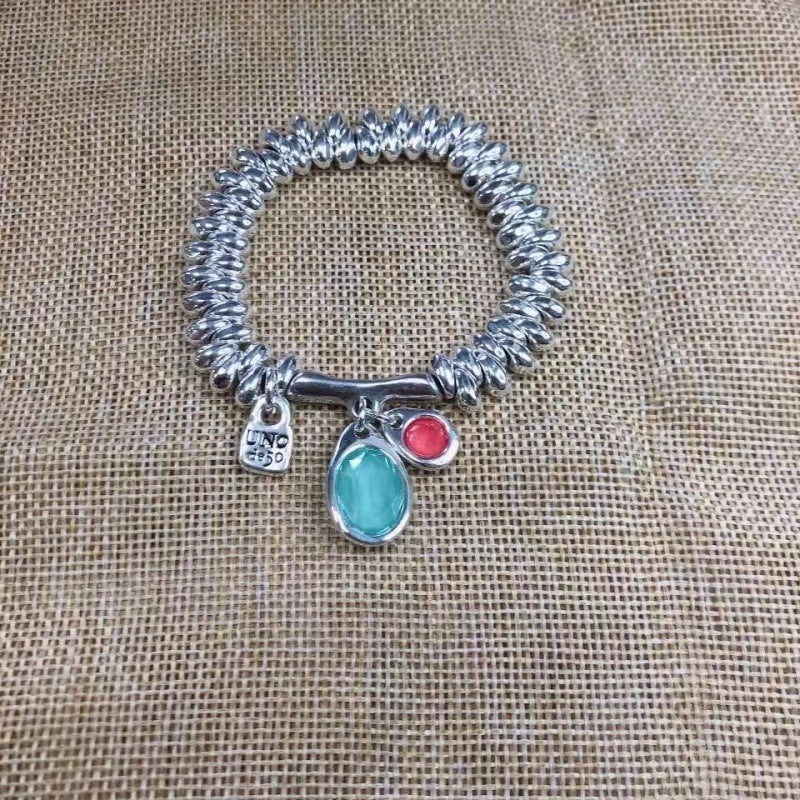 Stretch bracelet on neutral background showing textured beads. Alt: “UNO de 50 Stretch Bracelet – Silver Textured Beads.”