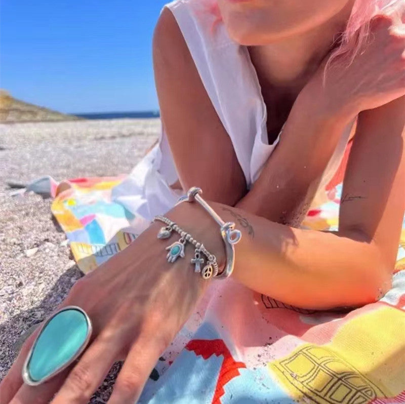 Beaded charm bracelet on neutral background. Alt: “UNOde50 Beaded Bracelet with Charms – Silver Charm Bracelet.”