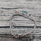 Silver bracelet with various charms on a textured surface