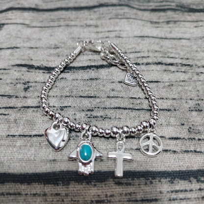 Silver bracelet with various charms on a textured surface