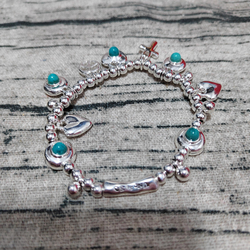 Silver bracelet with turquoise beads on a textured surface