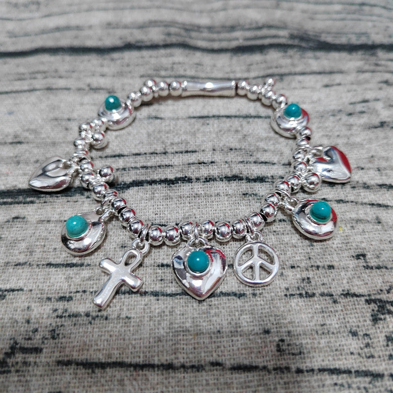Silver bracelet with various charms on a textured surface