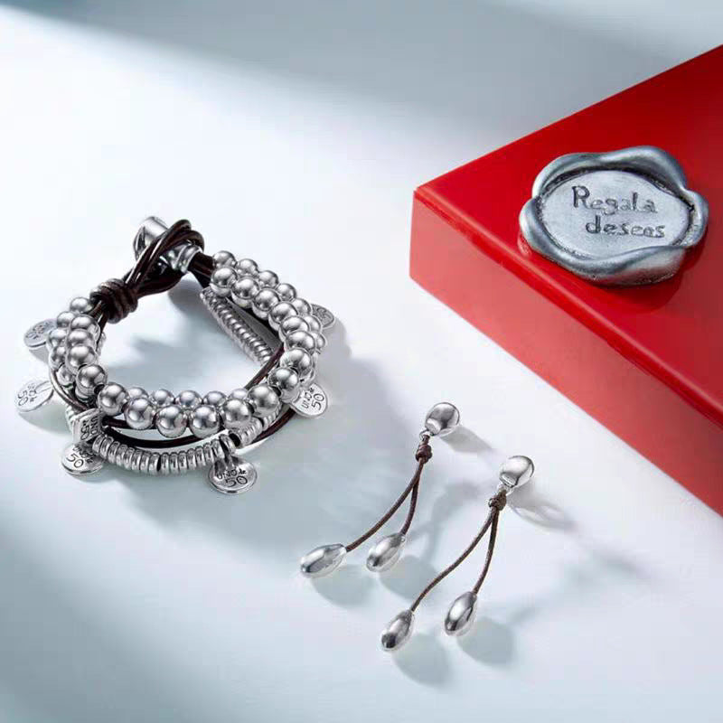 Wrap bracelet on neutral background showing leather and silver accents. Alt: “UNOde50 Bond Wrap Bracelet – Silver & Leather Wrap.”