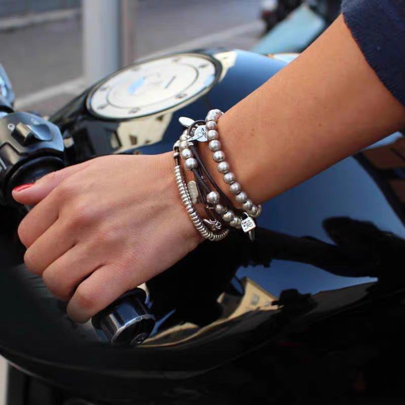 Wrap bracelet on neutral background showing leather and silver accents. Alt: “UNOde50 Bond Wrap Bracelet – Silver & Leather Wrap.”