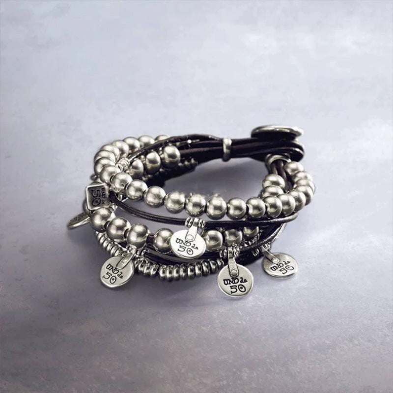 Wrap bracelet on neutral background showing leather and silver accents. Alt: “UNOde50 Bond Wrap Bracelet – Silver & Leather Wrap.”
