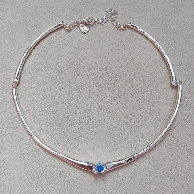  Choker on neutral or textured background. Alt: “UNOde50 Choker Necklace with White Cubic Zirconia.”