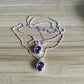 Two silver beaded chain necklaces with oval black gemstone pendants, displayed on a light wood grain surface.