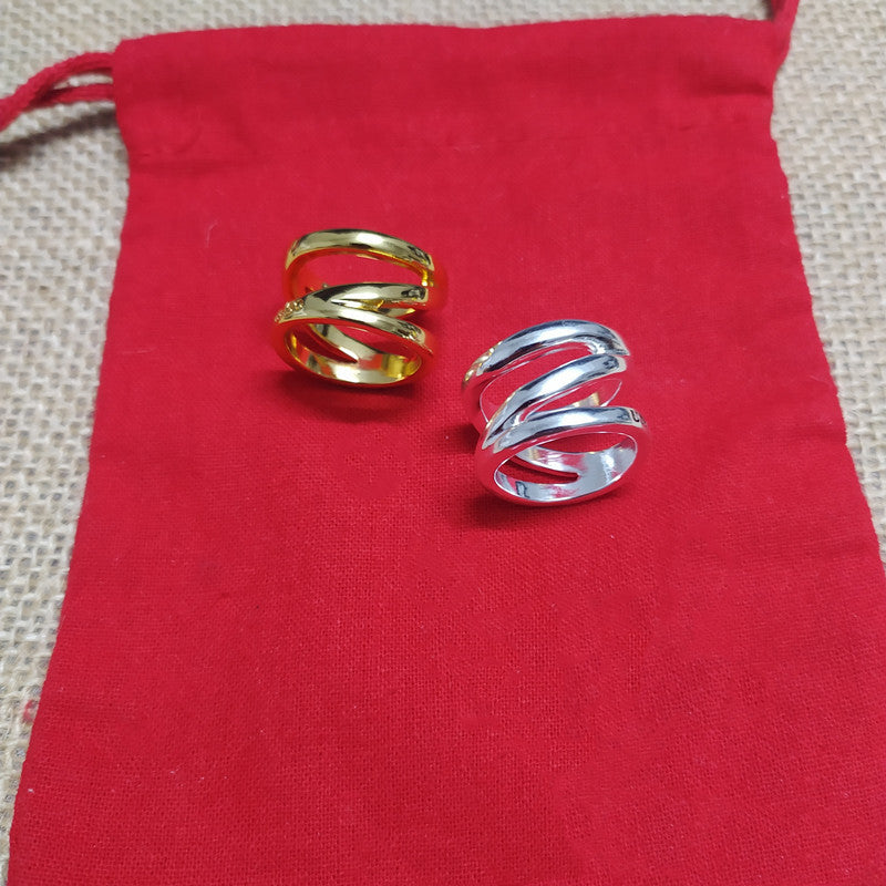 Two spiral wrap-style rings, one gold-toned and one silver-toned, displayed on a red fabric pouch over a beige woven surface.