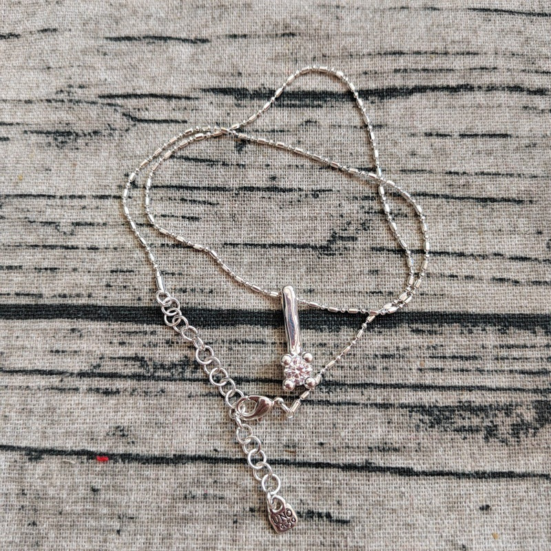 Silver necklace with a pendant on a textured surface