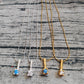 Four necklaces with pendants on a textured surface