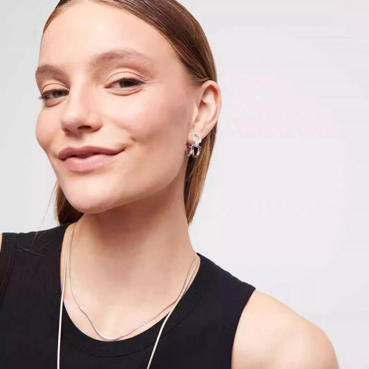 Earrings worn as elegant statement. Alt: “Sparkling Edge: UNOde50 Topaz Hoops.”