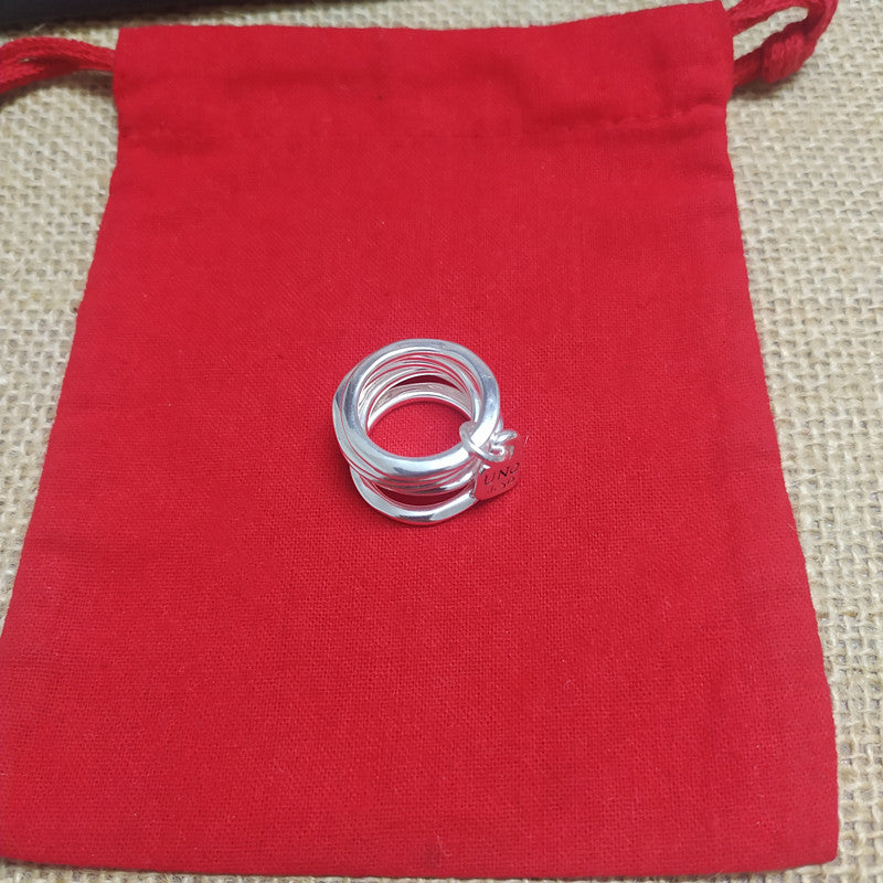  Multi-row ring on neutral background showing stacked bands and charm. Alt: “UNOde50 Multi-Row Ring with a Charm – Silver Stacked Ring.”

