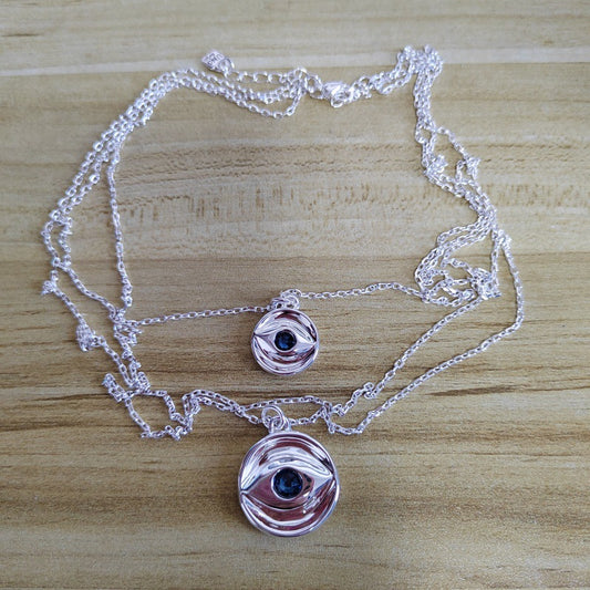 Multi-strand necklace displayed with evil eye charm. Alt: “UNOde50 Multi-Strand Chain Necklace with Evil Eye.”