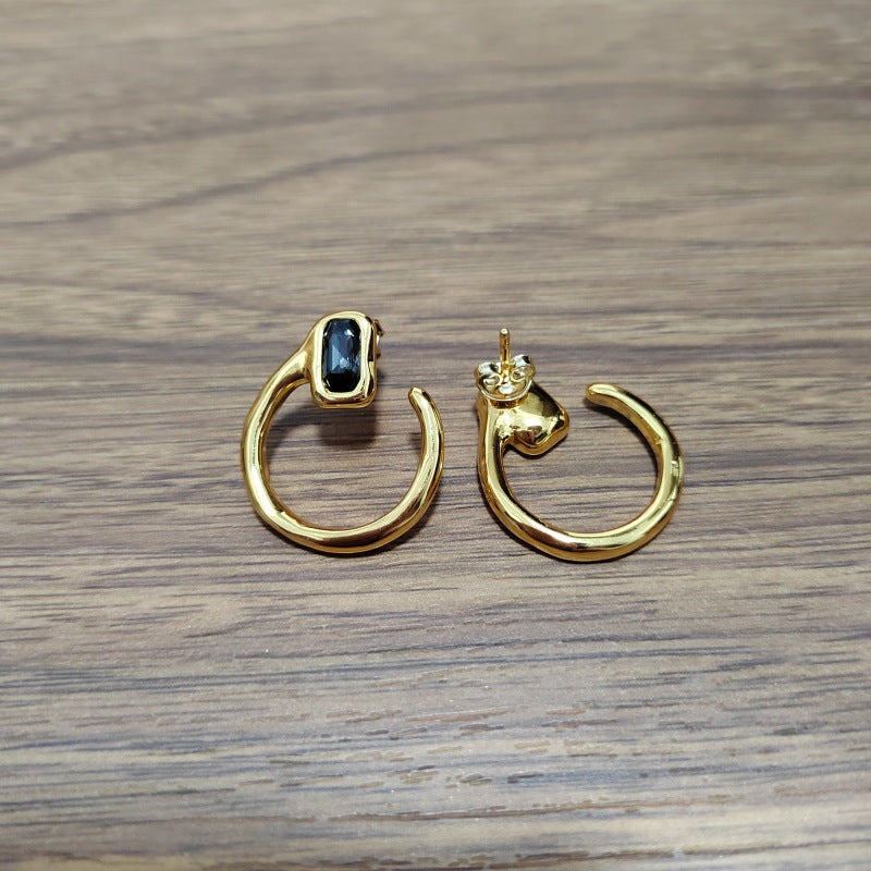 Needle-shaped earrings on neutral background. Alt: “UNOde50 Needle-Shaped Earrings – Sterling Silver-Plated Drops.”