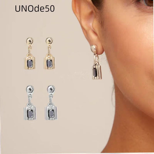Earrings worn as symbolic statement. Alt: “Locked In: UNOde50 Padlock Earrings.”