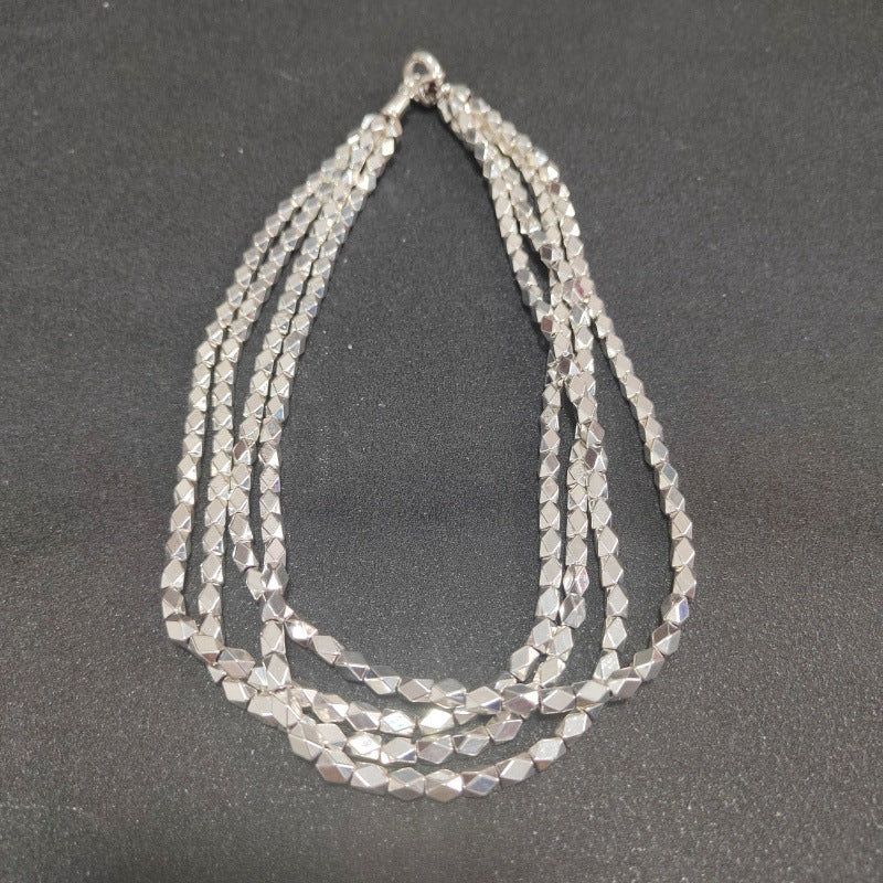 Necklace on neutral background. Alt: “UNOde50 Paths Necklace – Silver Layered Link Jewelry.”