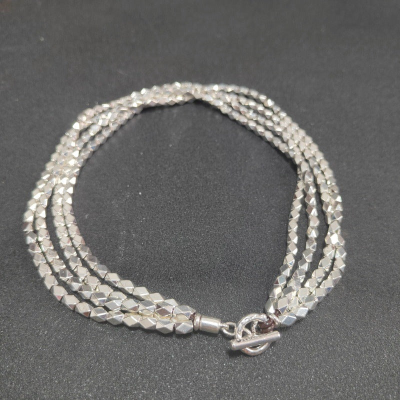 Necklace on neutral background. Alt: “UNOde50 Paths Necklace – Silver Layered Link Jewelry.”