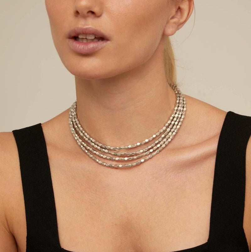 Necklace worn as meaningful statement. Alt: “Journey's Path: UNOde50 Paths Necklace.”