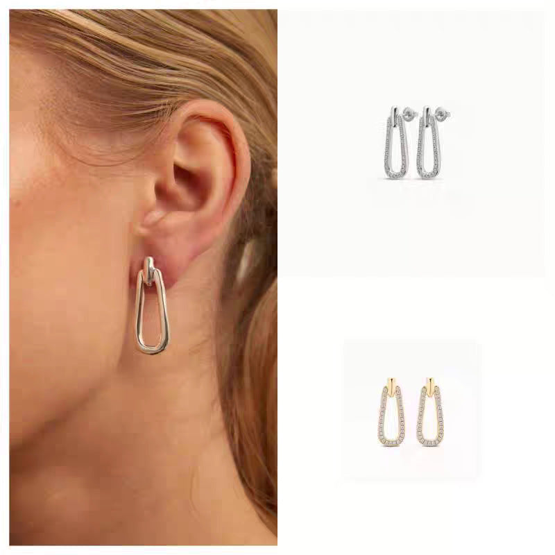 Earrings on neutral or prosperity-themed background. Alt: “UNOde50 Prosperity Earrings – Silver Symbolic Drops.”