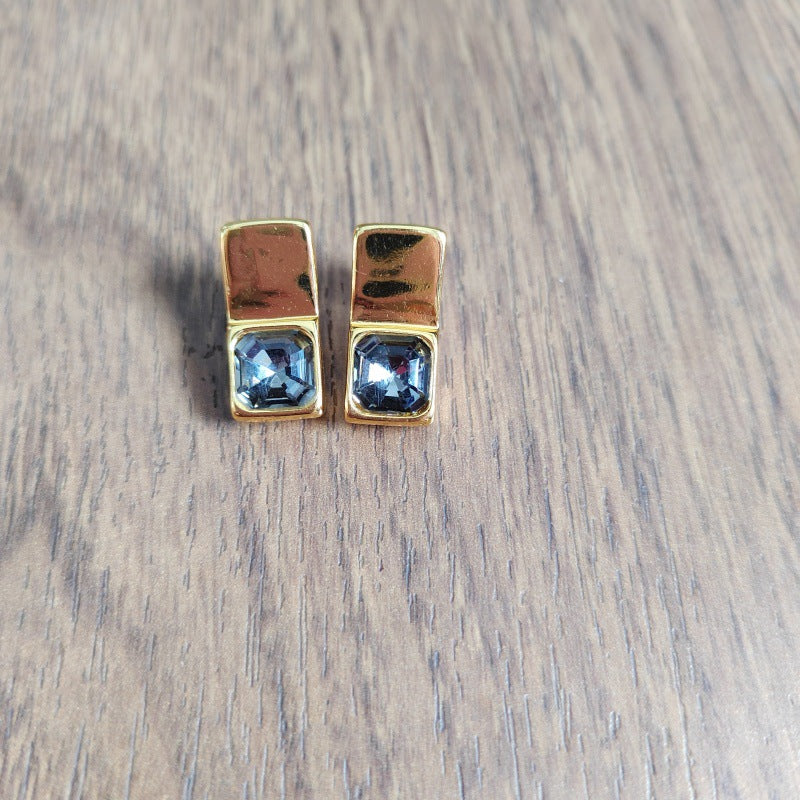 Rectangular studs on neutral background. Alt: “UNOde50 Rectangular-Shaped Stud Earrings – Silver Geometric Studs.”