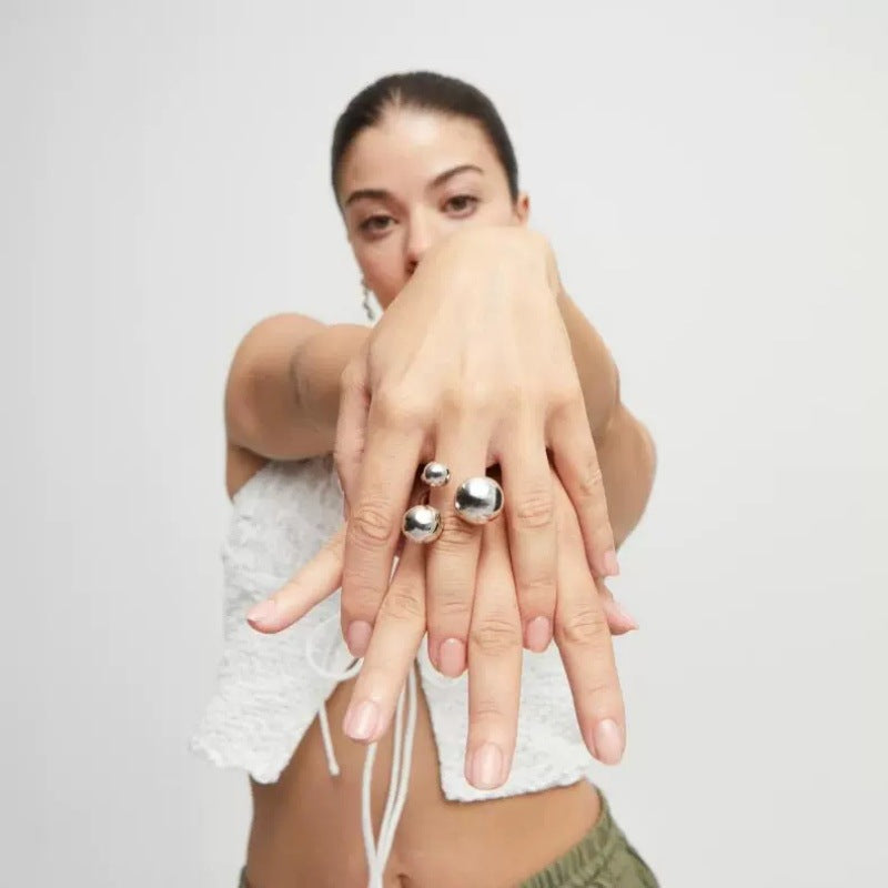 Ring worn as playful statement. Alt: “Sculptural Play: UNOde50 Bubble Bead Ring.”