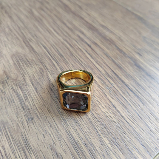 Square ring on neutral or geometric background. Alt: “UNOde50 Square Shape Ring with Crystal – Silver Geometric.”