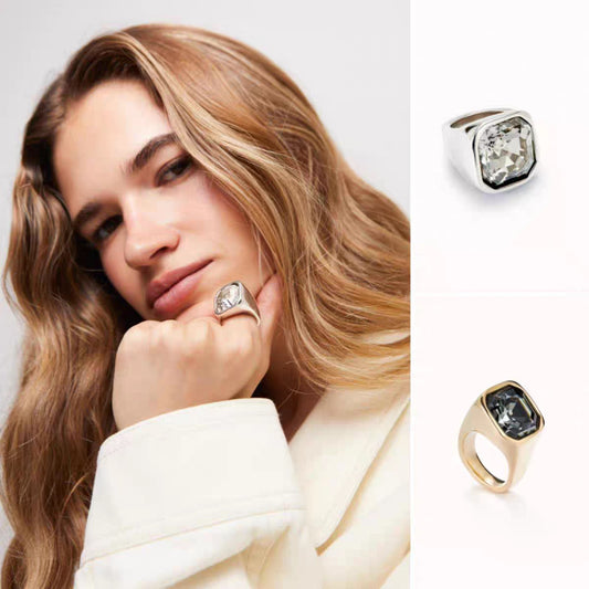 Square ring on neutral or geometric background. Alt: “UNOde50 Square Shape Ring with Crystal – Silver Geometric.”