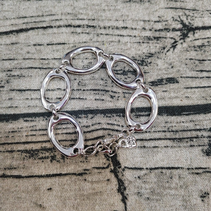  The One bracelet on neutral background showing sculptural form. Alt: “UNOde50 The One Bracelet – Silver Textured Cuff.”