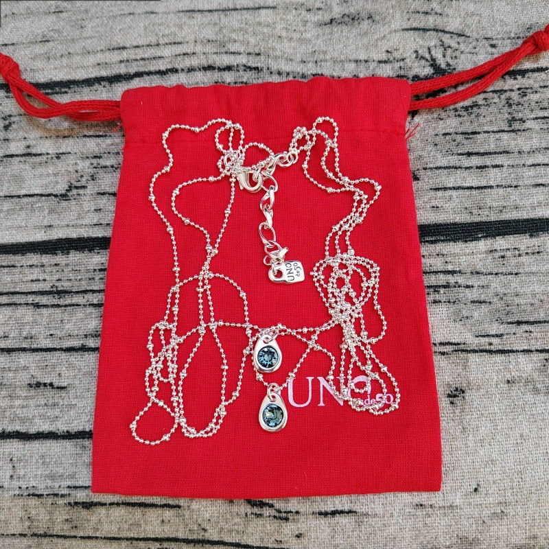 Pendant on neutral background. Alt: “Uno de 50 Multi-Strand Chain Pendant Necklace with Crystal.”