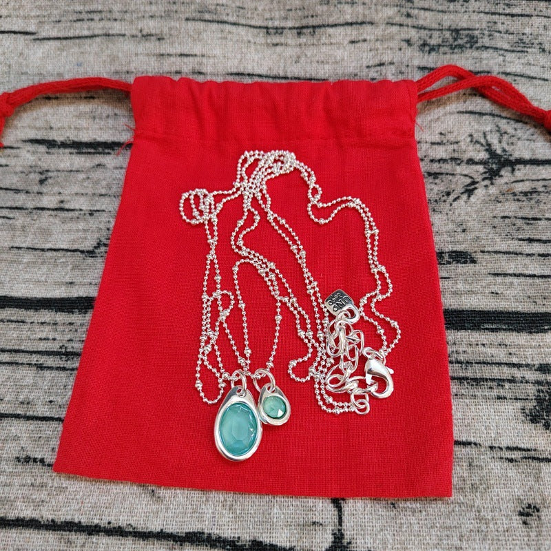 Pendant on neutral background. Alt: “Uno de 50 Multi-Strand Chain Pendant Necklace with Crystal.”