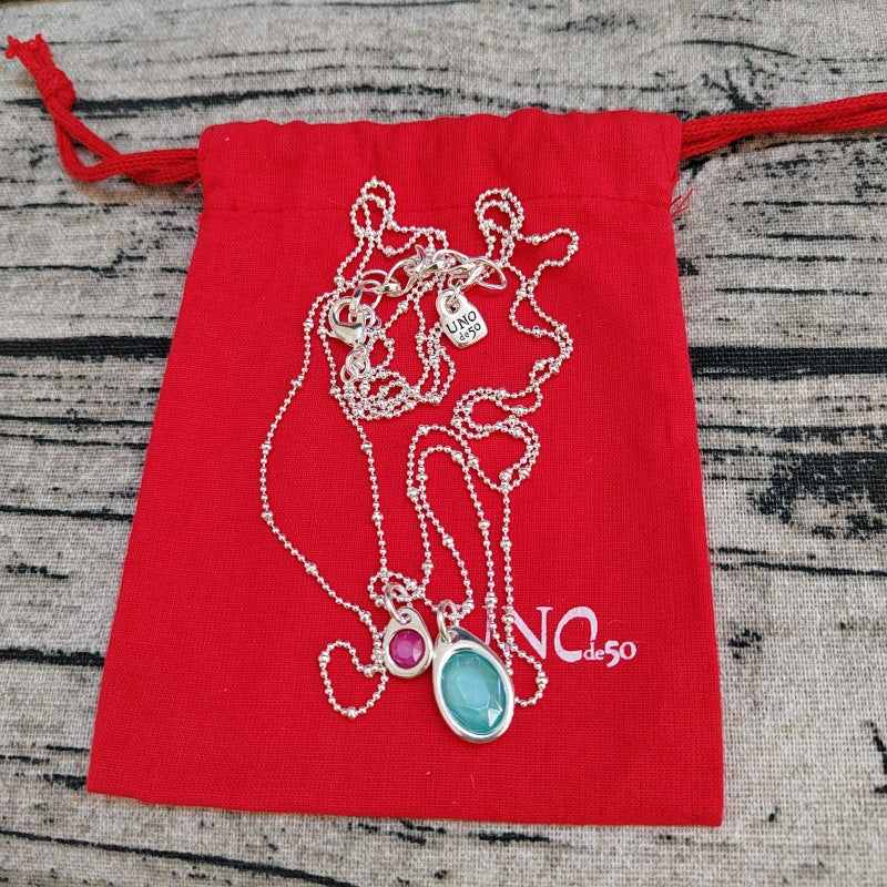 Pendant on neutral background. Alt: “Uno de 50 Multi-Strand Chain Pendant Necklace with Crystal.”