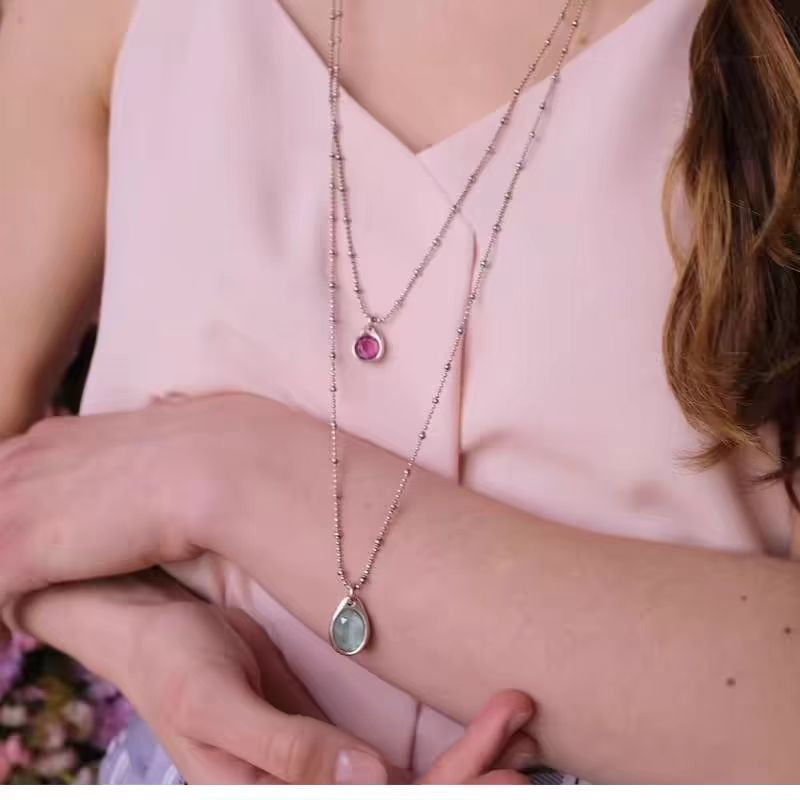 Necklace worn as bold statement. Alt: “Artistic Edge: Uno de 50 Crystal Pendant.”