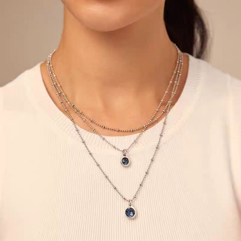 Necklace worn as bold statement. Alt: “Artistic Edge: Uno de 50 Crystal Pendant.”