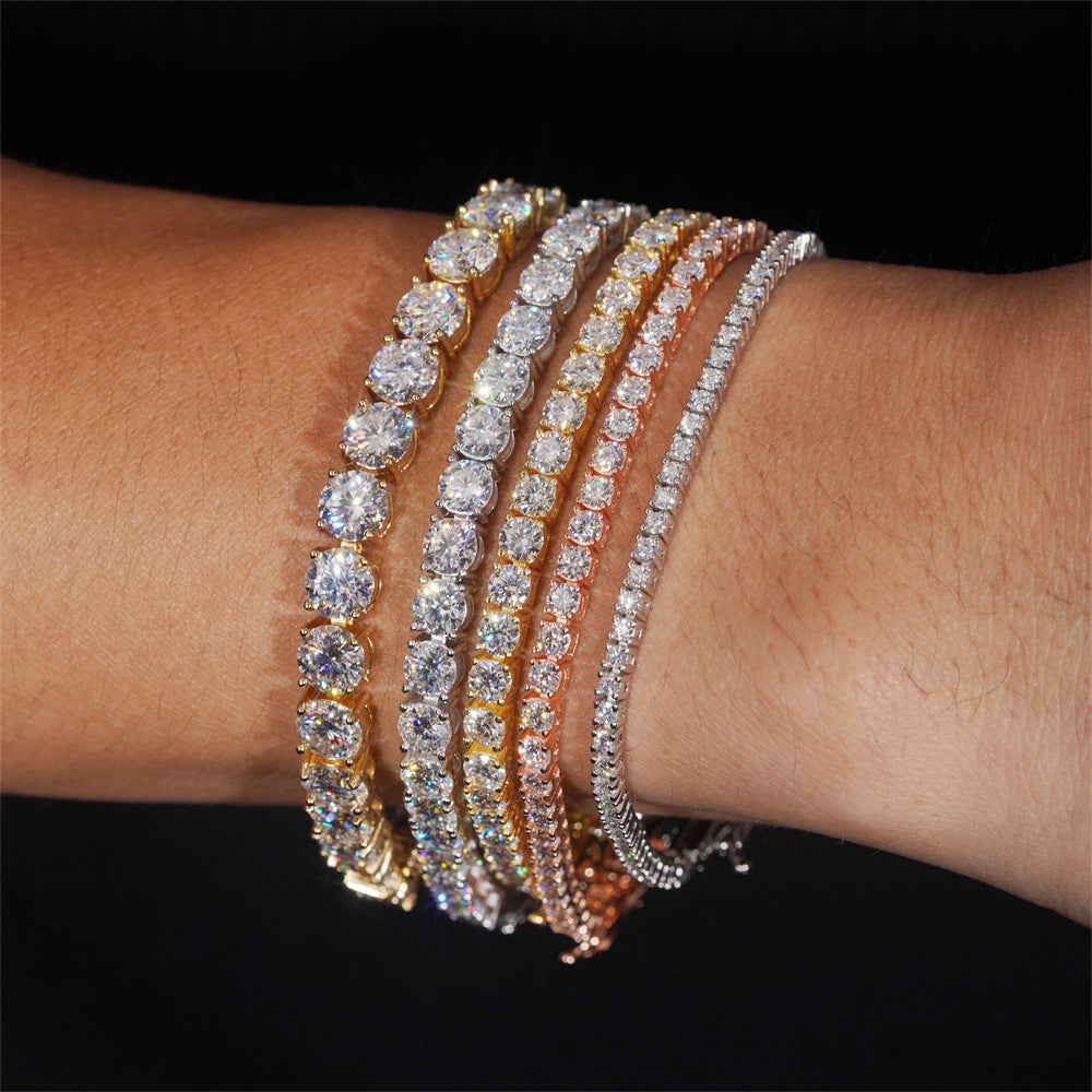 Stack of diamond bracelets on a wrist against a black background
