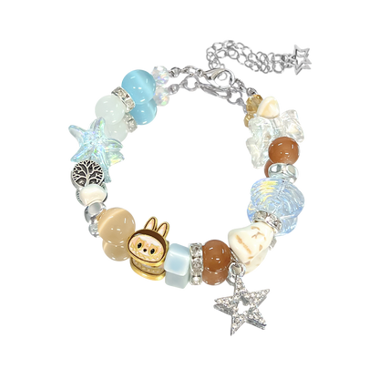Bracelet with various charms including a small animal figure, starfish, and heart on a white background