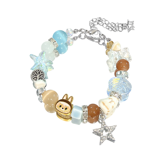 Bracelet with various charms including a small animal figure, starfish, and heart on a white background