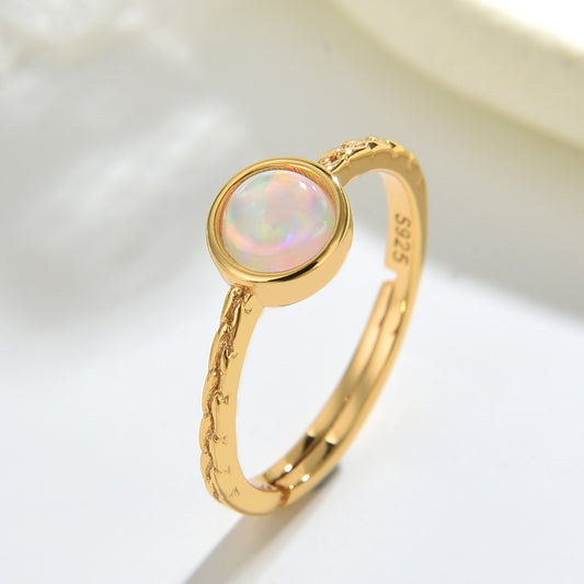 Gold ring with a colorful gemstone on a light background