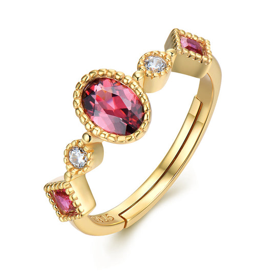 Gold ring with red gemstone on a white background