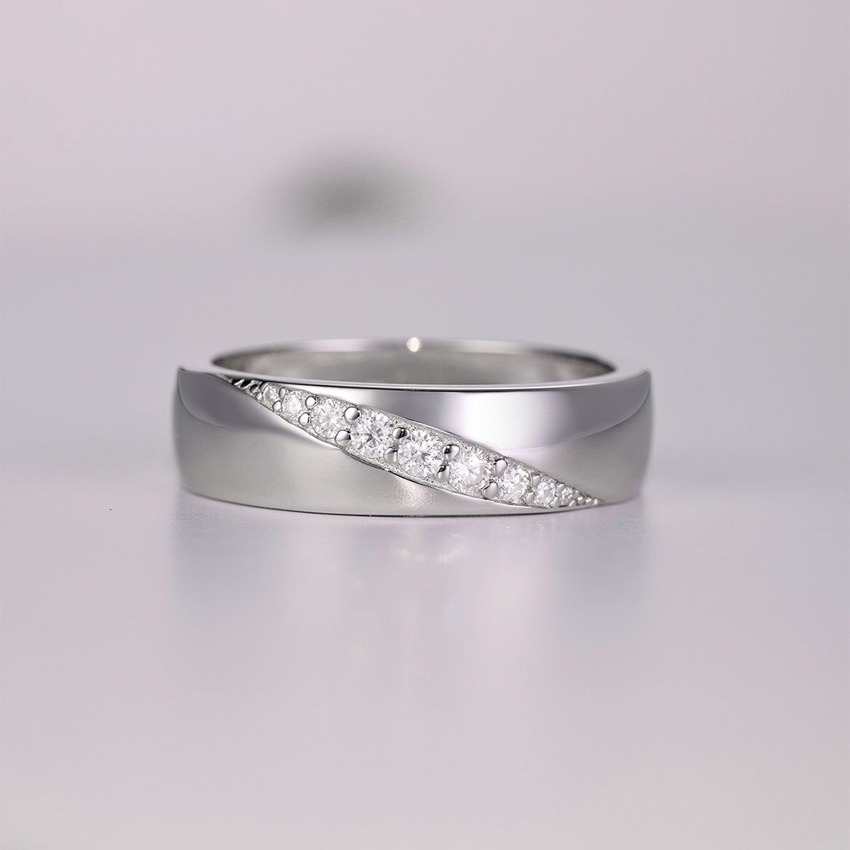 Bold flat lay featuring 4–5 wide-band rings on textured, unisex backdrop. Alt: “Wide-Band Moissanite Engagement Rings – Unisex Bold Collection.”